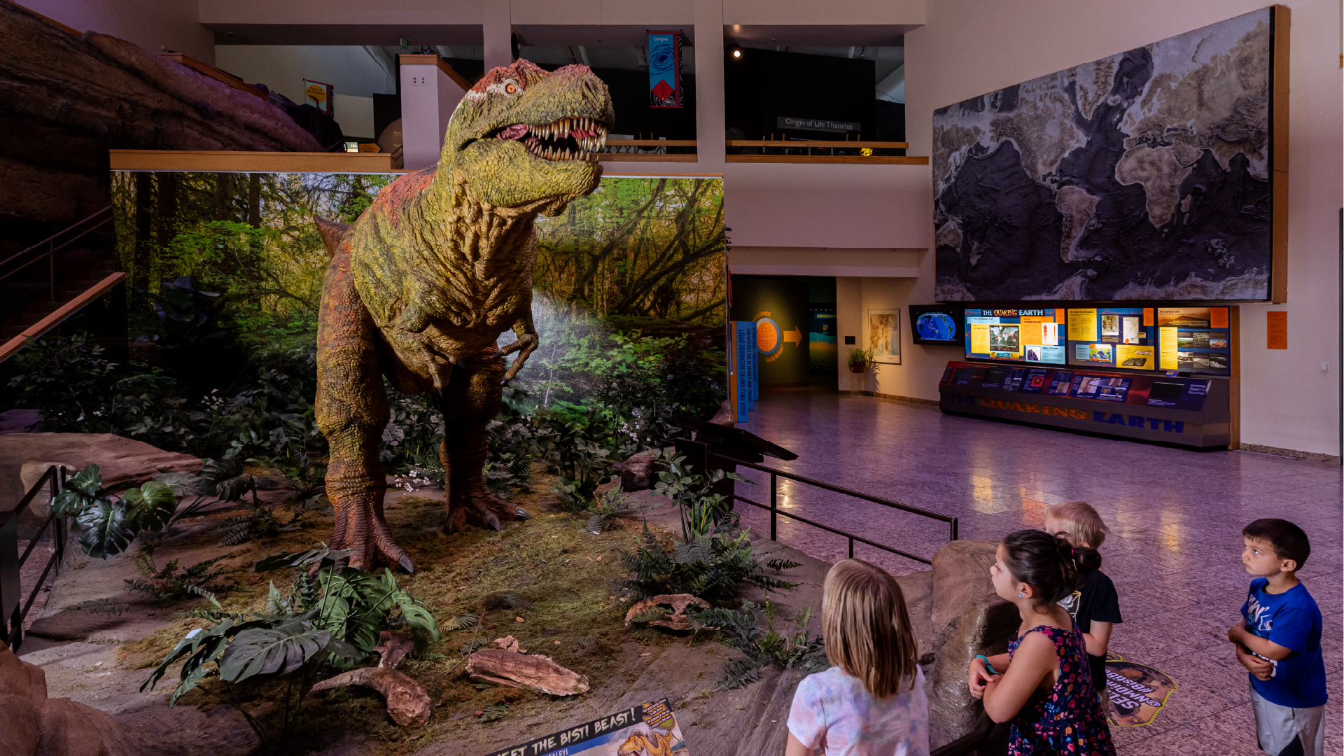 Group of kids looking upward to an T. Rex exhibit.