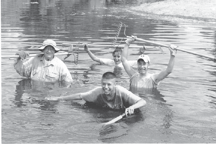 RG_SwimmingWithRakes Volunteer and students at the Nature Center
